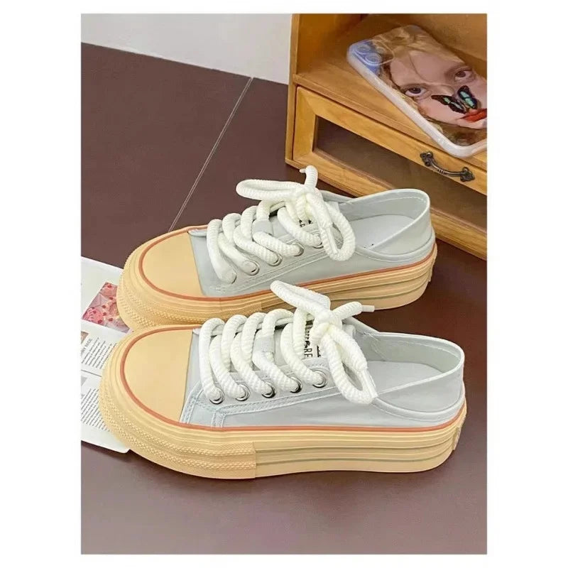 Pair of sneakers with white laces on a surface with a wooden shelf in the background.