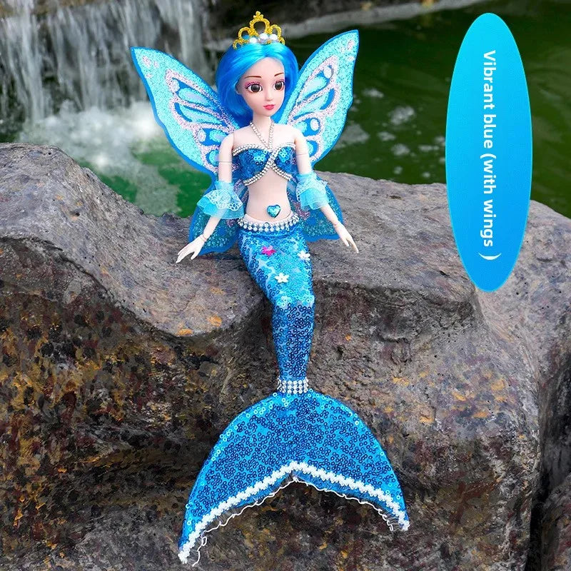Blue fairy doll with wings sitting on a rock by a water fountain