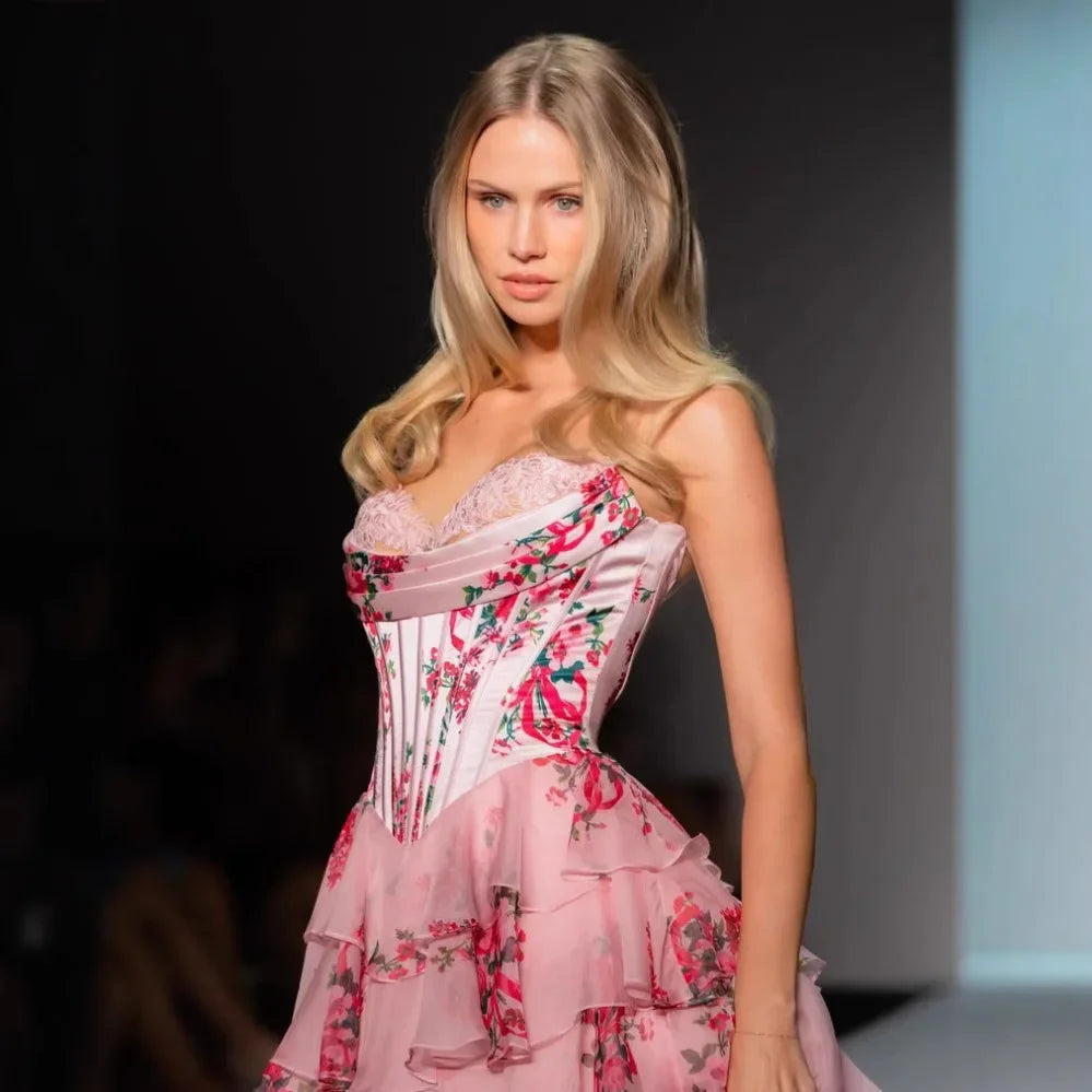 Model wearing a pink floral dress on a runway